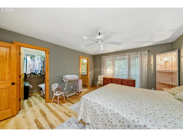 a bedroom with a bed and a dresser next to a window