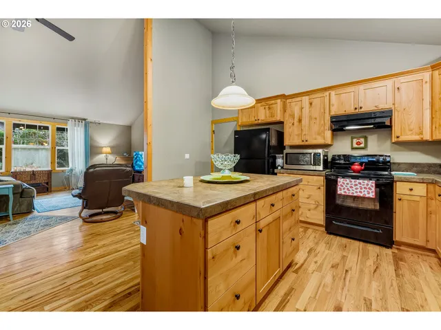 a kitchen with kitchen island a stove a sink a refrigerator dining table and chairs