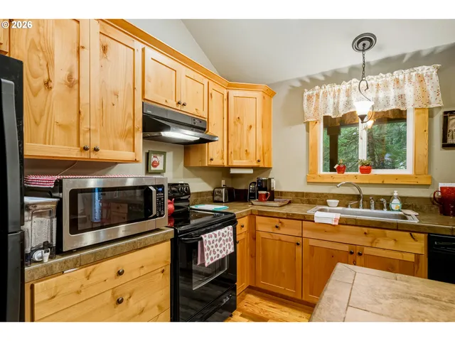 a kitchen with stainless steel appliances granite countertop a sink a stove and a microwave