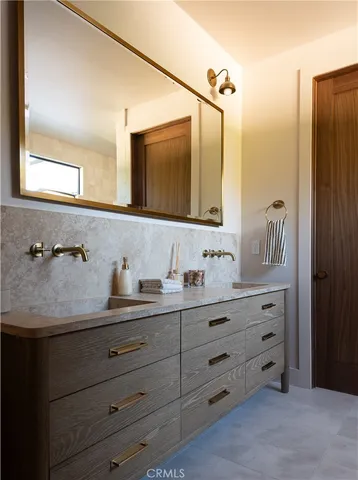 a bathroom with a granite countertop sink a toilet and a mirror