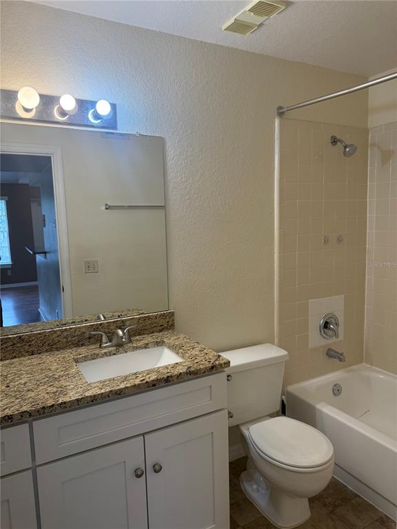 1049 South Hiawassee Road, Unit 3428 Orlando, FL 32835 - Photo 16 of 21 a bathroom with a granite countertop toilet a sink and a bathtub