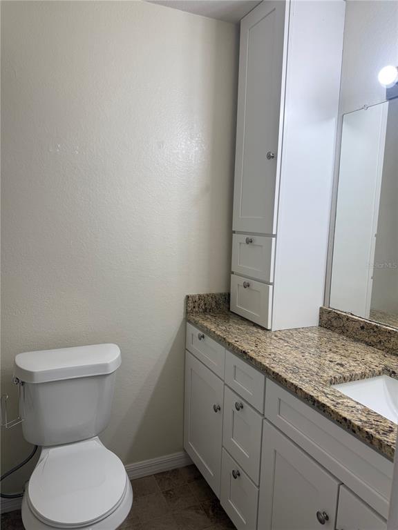 1049 South Hiawassee Road, Unit 3428 Orlando, FL 32835 - Photo 20 of 21 a bathroom with a granite countertop toilet and sink