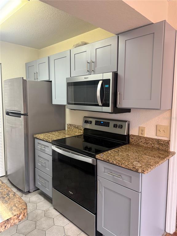 1049 South Hiawassee Road, Unit 3428 Orlando, FL 32835 - Photo 10 of 21 a kitchen with a stove and a microwave