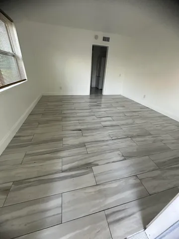 a view of an empty room and wooden floor