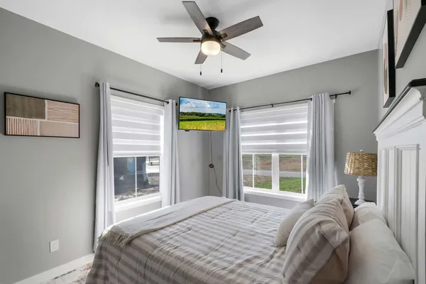 a bedroom with a bed and a large window