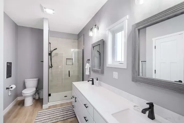 a large bathroom with a sink a toilet a shower and a mirror