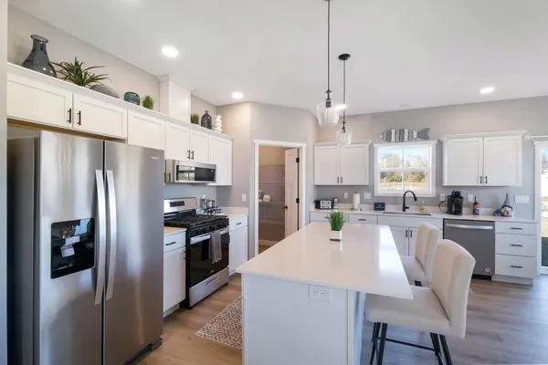 a kitchen with refrigerator a sink and chairs