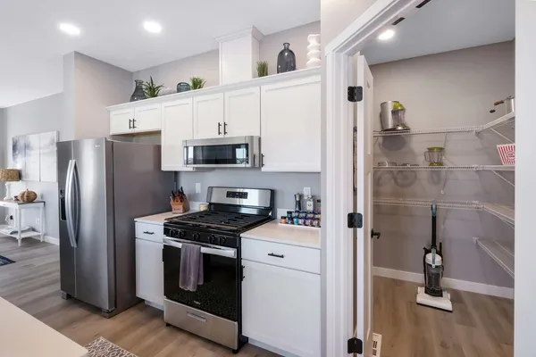 a kitchen with a refrigerator stove and white cabinets