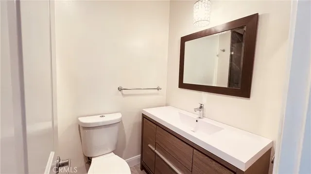 a bathroom with a toilet a sink and mirror