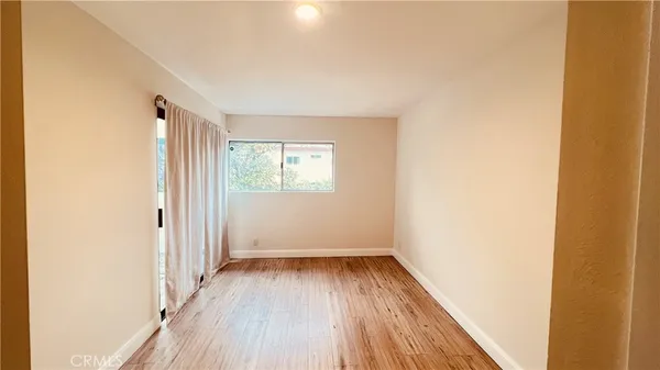 a view of a room with wooden floor and a window