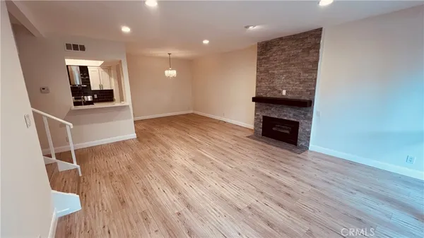 an empty room with wooden floor and a sink