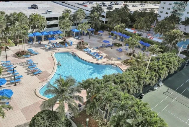 an aerial view of a swimming pool with outdoor seating