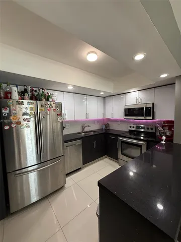 a kitchen with a refrigerator and a sink