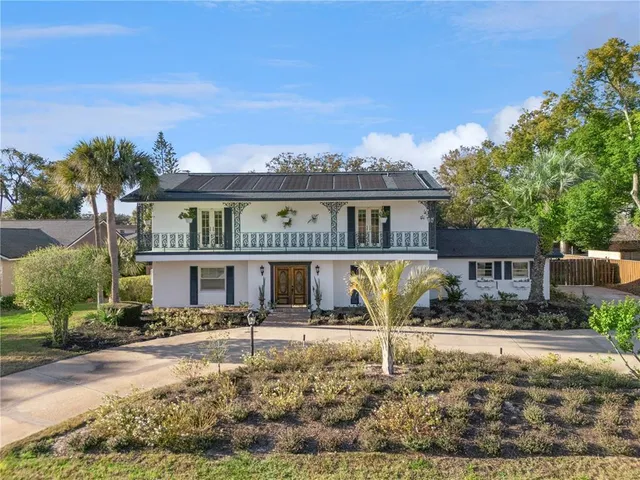 a front view of a house with large trees