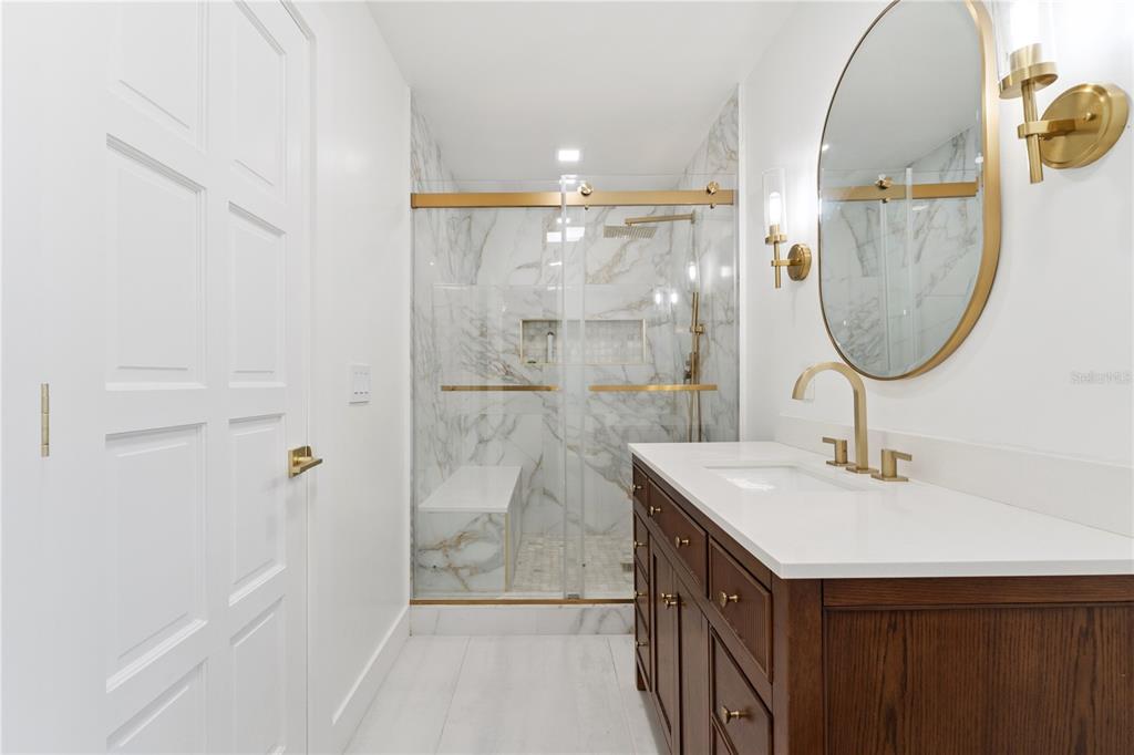 7621 Orange Tree Lane Orlando, FL 32819 - Photo 30 of 47 a bathroom with a sink a mirror and a shower