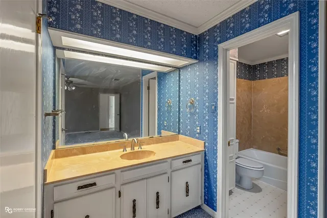 a bathroom with a sink a toilet a mirror and shower