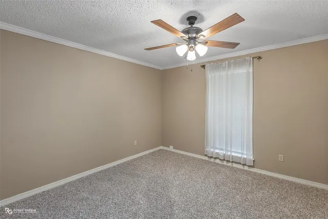 an empty room with a window and a fan