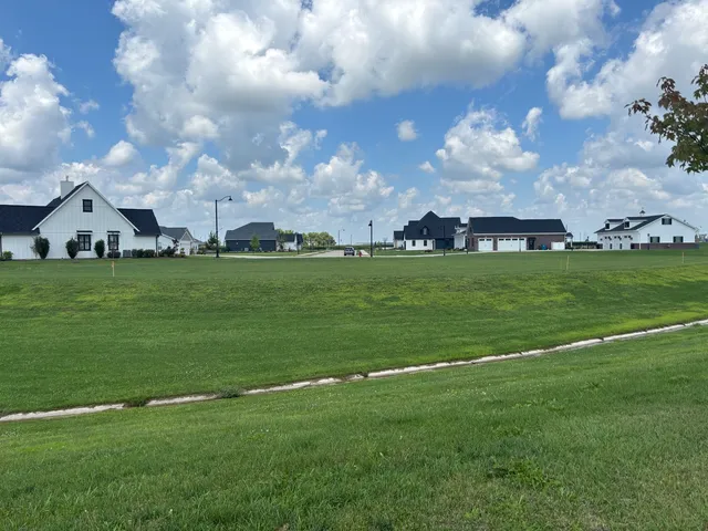 a backyard of a house with lots of green space table and chairs