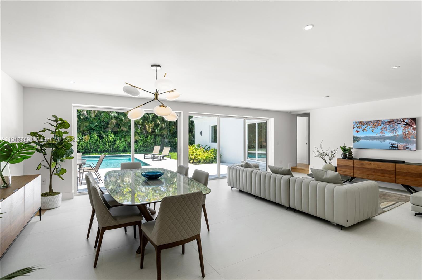 45 Northeast 104th Street Miami Shores, FL 33138 - Photo 13 of 52 a dining room with furniture a chandelier and large windows