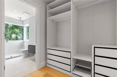 a bathroom with a granite countertop sink a toilet a mirror and shower