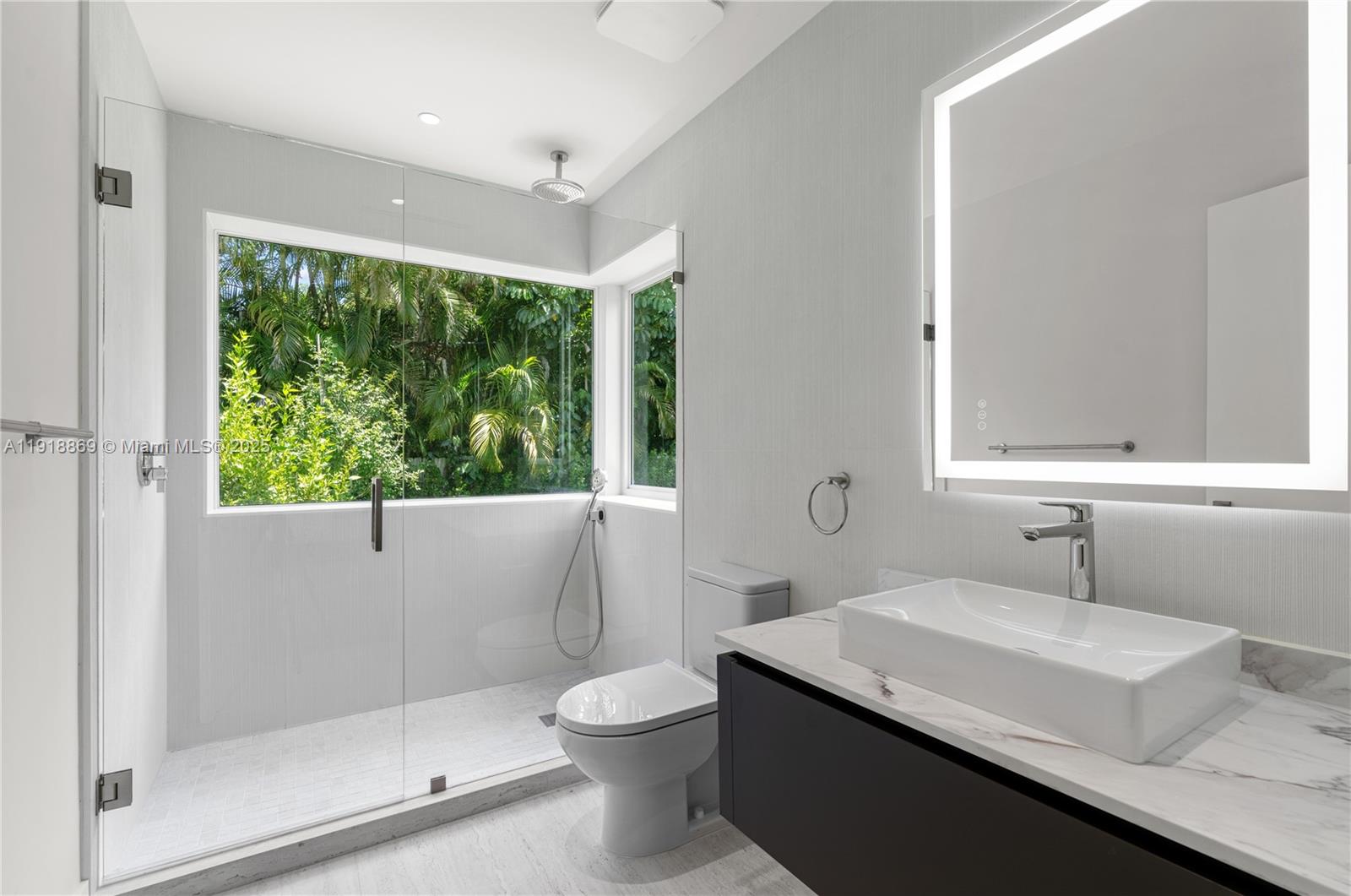 45 Northeast 104th Street Miami Shores, FL 33138 - Photo 35 of 52 a bathroom with a granite countertop sink a toilet a mirror and shower