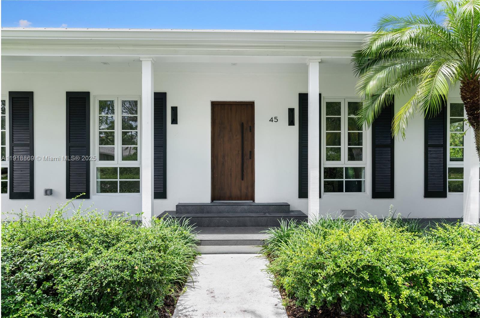 45 Northeast 104th Street Miami Shores, FL 33138 - Photo 4 of 52 front view of a house with a large window and a potted plant