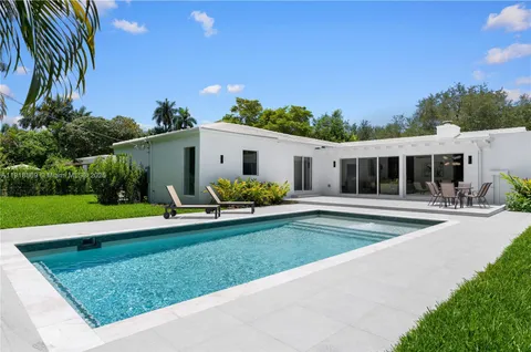 a swimming pool with outdoor seating and yard