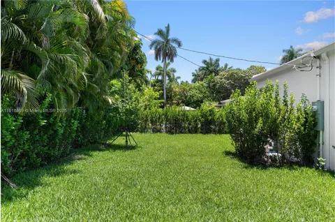 an aerial view of a house with a yard and a fountain