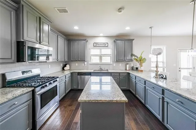 a kitchen with stainless steel appliances granite countertop a stove and a sink