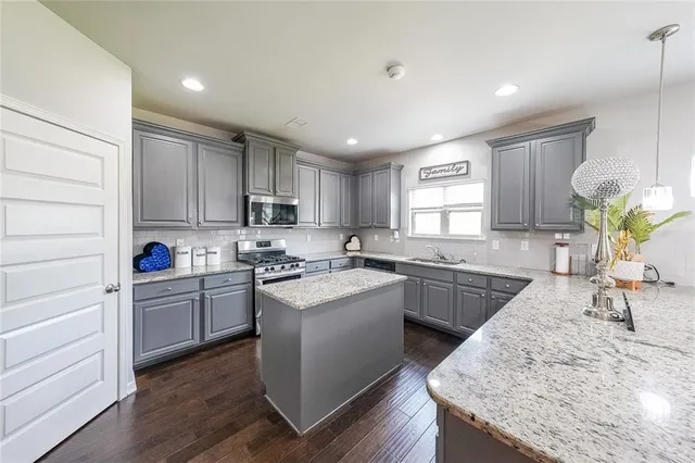 a kitchen with granite countertop cabinets stainless steel appliances and sink