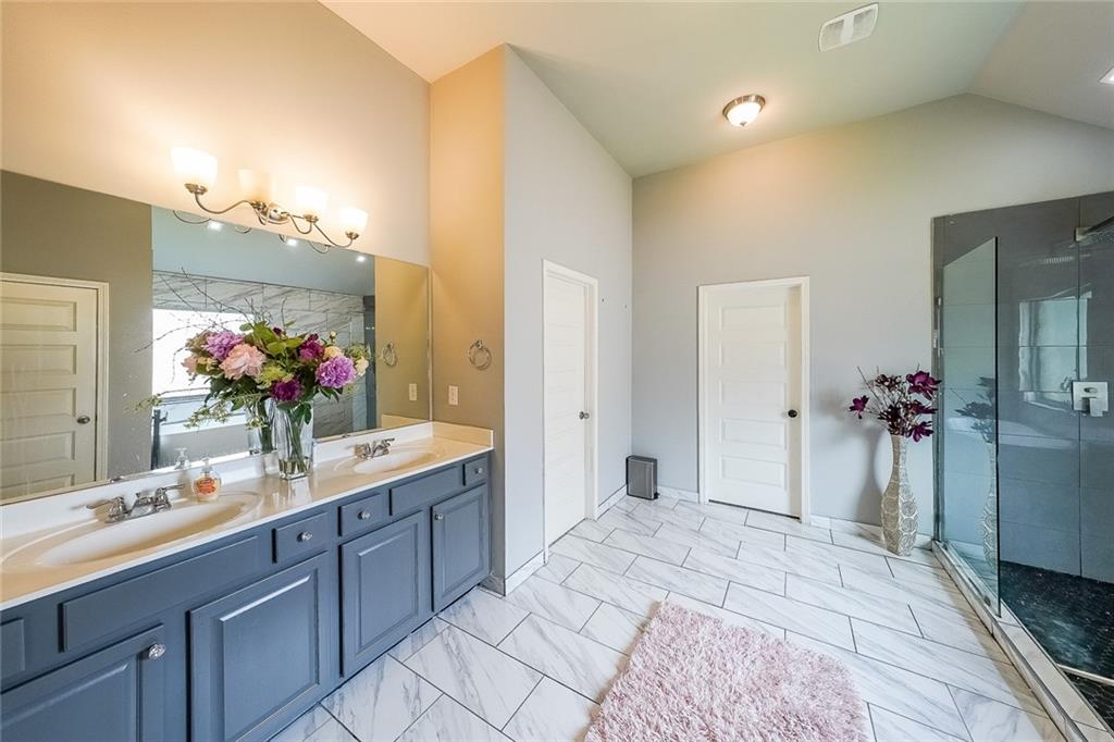 8097 White Oak Loop Lithonia, GA 30038 - Photo 19 of 25 a spacious bathroom with a granite countertop sink and a mirror