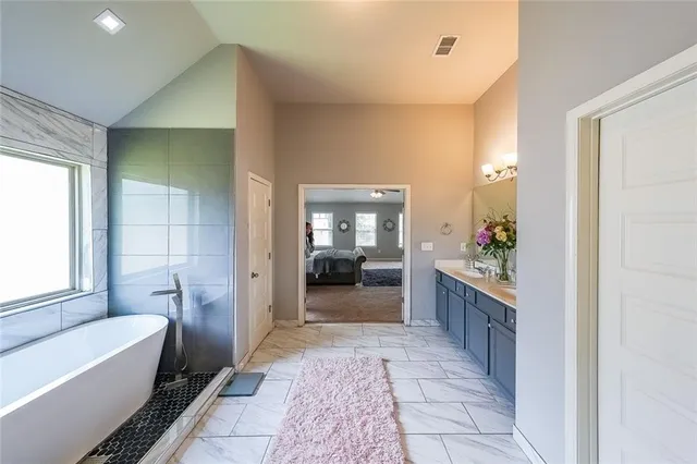 a bathroom with a tub sink and mirror