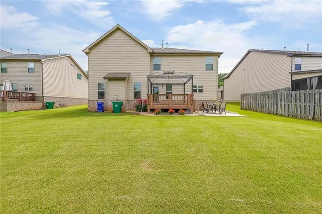 a view of a house with a big yard and large trees
