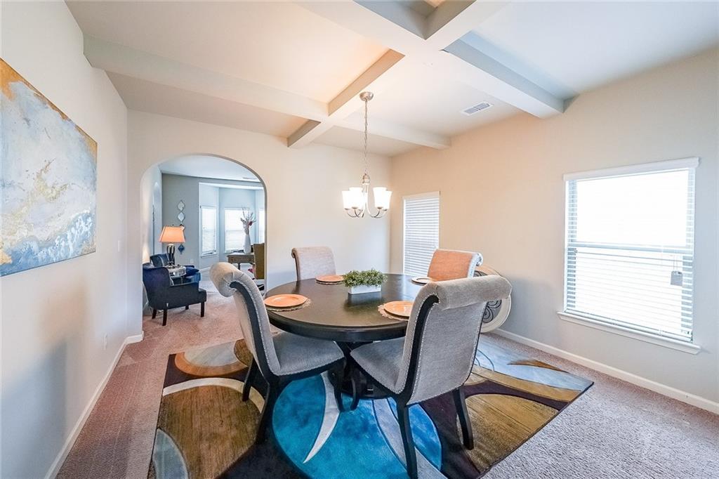 8097 White Oak Loop Lithonia, GA 30038 - Photo 9 of 25 a dining room with furniture a chandelier and wooden floor