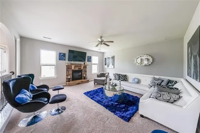 a living room with furniture a fireplace and a window
