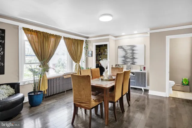 a dining room with furniture window and wooden floor