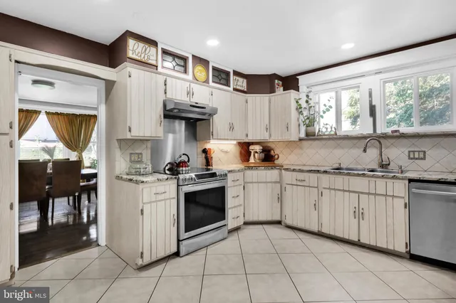 a kitchen with granite countertop a sink stove and cabinets