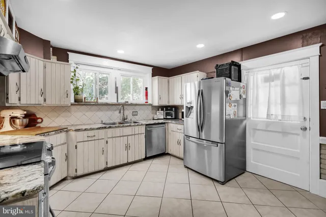 a kitchen with granite countertop a refrigerator and a sink