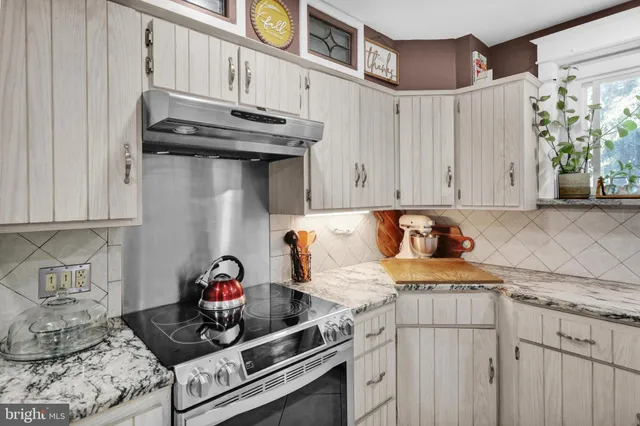 a kitchen with stainless steel appliances granite countertop a stove and a cabinets