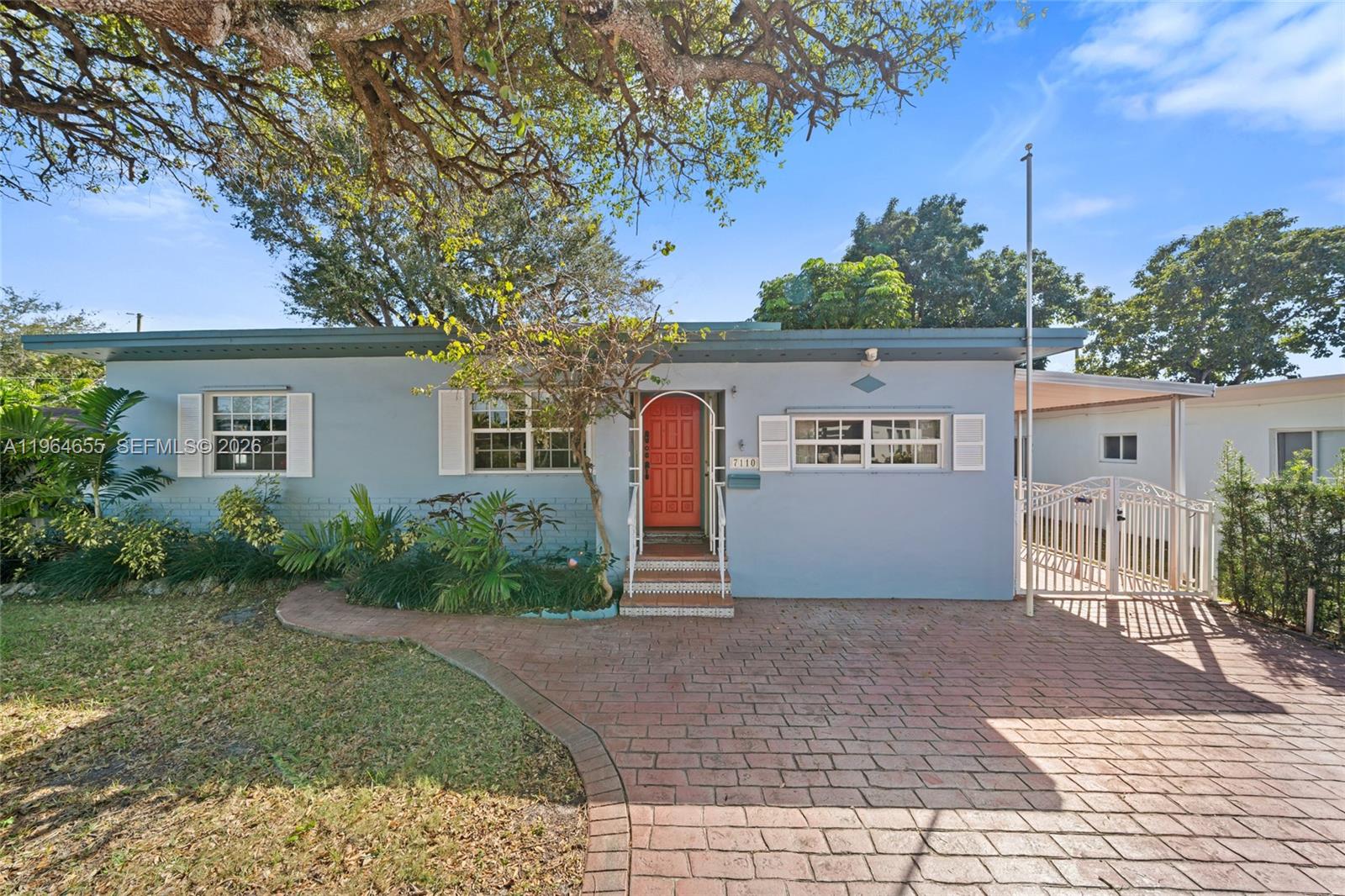 7110 Southwest 13th Terrace Miami, FL 33144 - Photo 1 of 39 a front view of a house with a yard and a garage