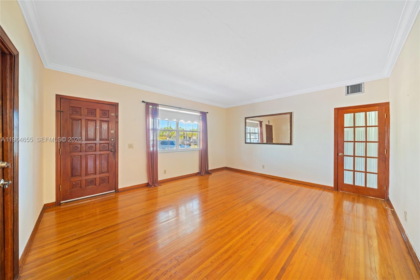 7110 Southwest 13th Terrace Miami, FL 33144 - Photo 5 of 39 a view of an empty room with wooden floor and a window