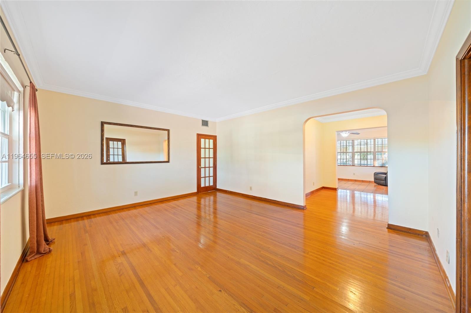 7110 Southwest 13th Terrace Miami, FL 33144 - Photo 6 of 39 a view of an empty room with wooden floor and a window