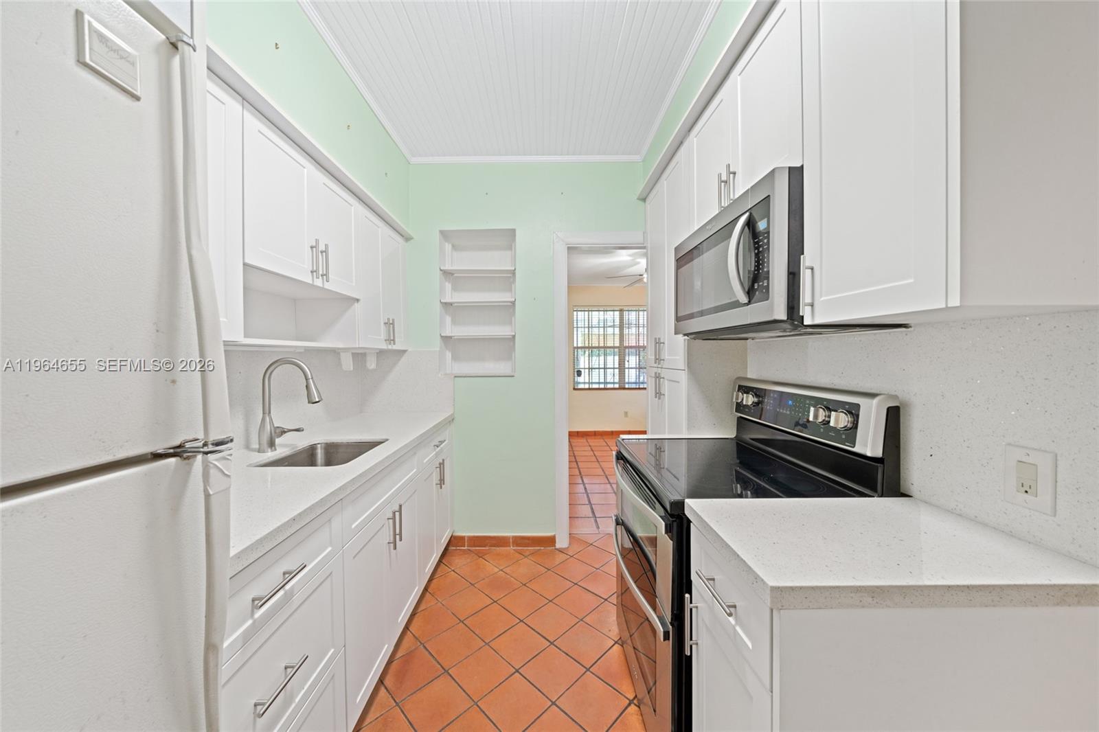 7110 Southwest 13th Terrace Miami, FL 33144 - Photo 10 of 39 a kitchen that has a sink and a stove in it
