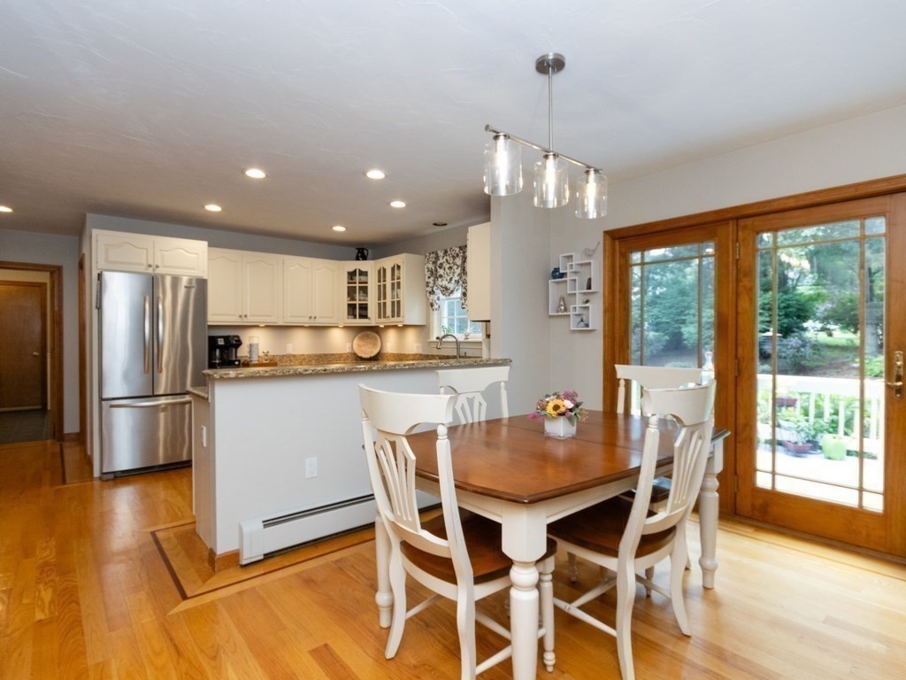 72 Emerson Road Walpole, MA 02032 - Photo 13 of 41 a kitchen with stainless steel appliances granite countertop a dining table chairs refrigerator and wooden floor