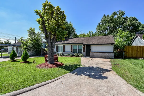 a front view of a house with a garden and yard