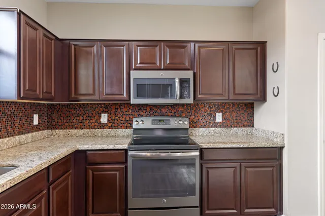 a kitchen with granite countertop a stove sink and cabinets