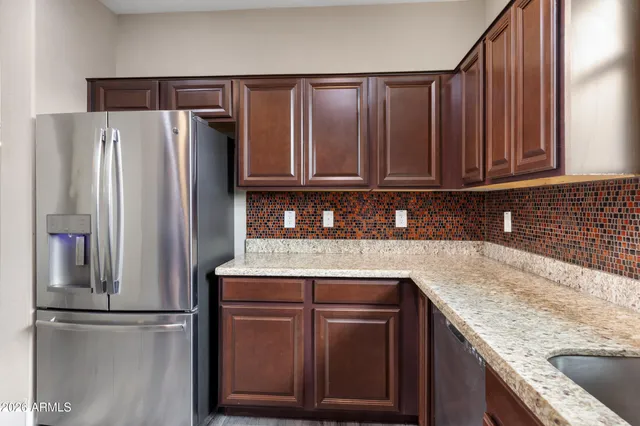 a kitchen with granite countertop a refrigerator and a sink