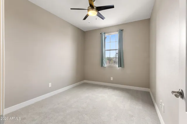 an empty room with a window and a fan