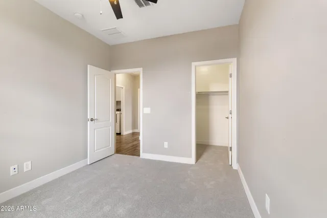 an empty room with closet and mirror