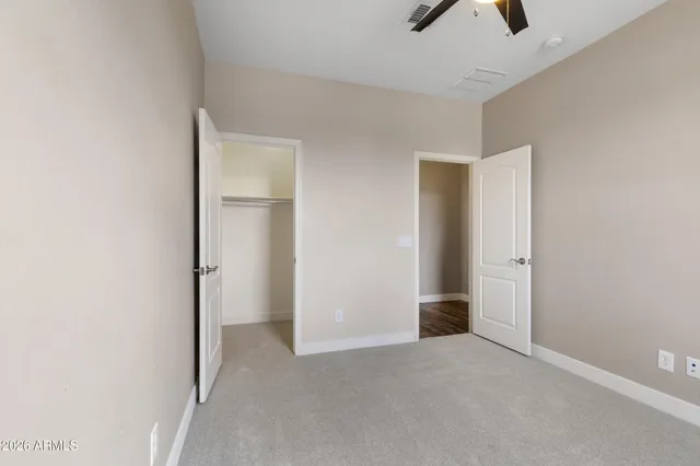 an empty room with ceiling fan and window